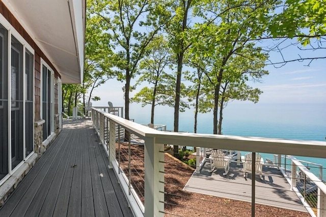 wooden terrace with a water view and a view of the beach