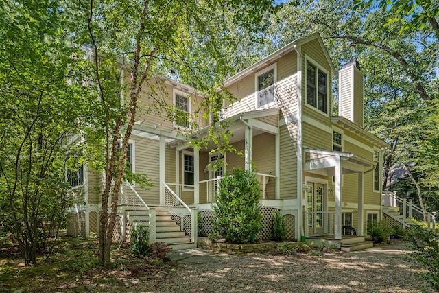 view of front of home featuring stairs and a chimney