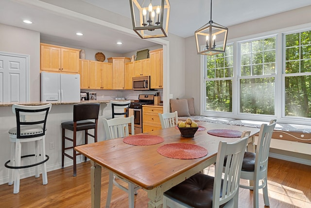 dining room with light hardwood / wood-style flooring and a notable chandelier