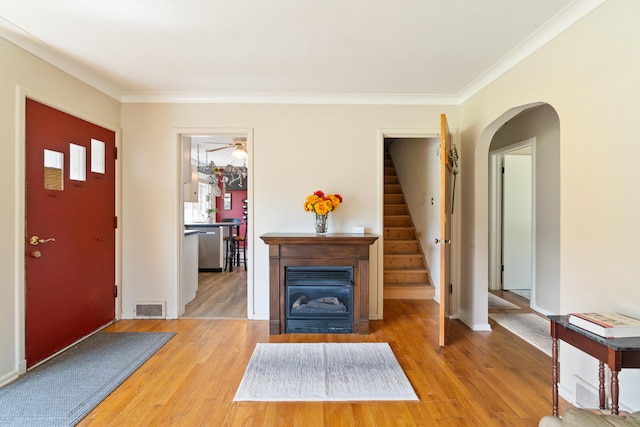 foyer entrance with hardwood / wood-style flooring and ornamental molding