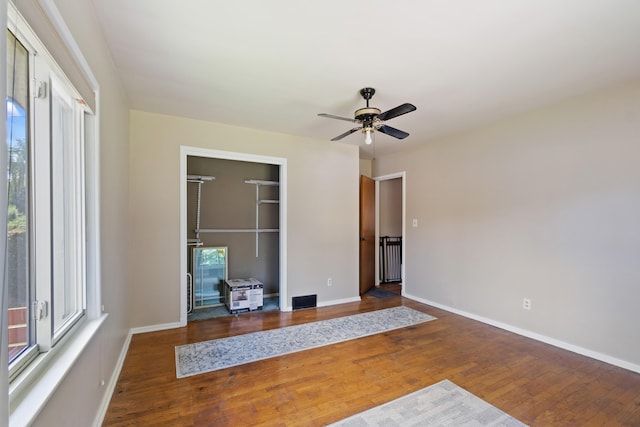 interior space with hardwood / wood-style flooring, ceiling fan, and a spacious closet