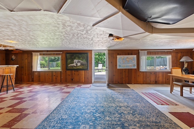 living room featuring wood walls and a textured ceiling