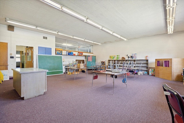 recreation room with a textured ceiling