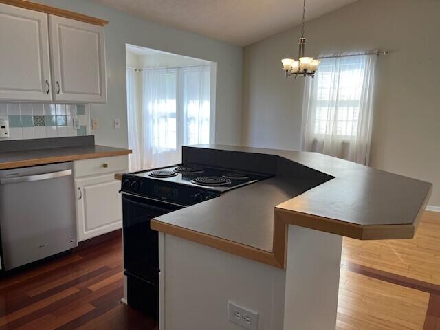 kitchen with dark wood-type flooring, dishwasher, black range with electric stovetop, and lofted ceiling