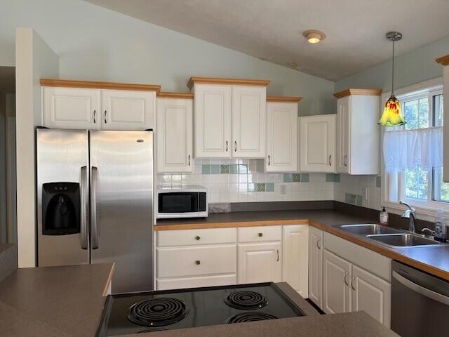 kitchen with tasteful backsplash, stainless steel appliances, lofted ceiling, and a sink