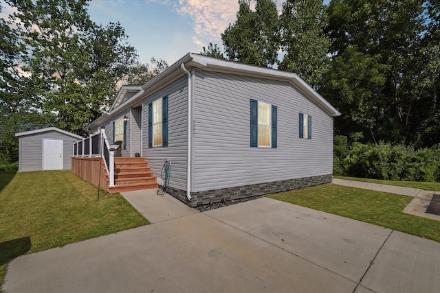 view of side of property featuring a wooden deck, a yard, and a shed