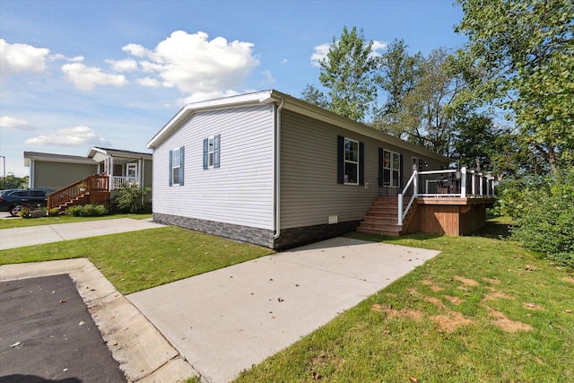 view of front of home with a deck and a front lawn