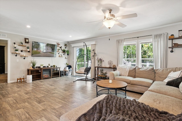 living room with light wood-type flooring, ceiling fan, and crown molding