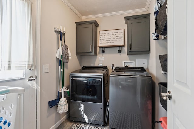 clothes washing area with washer and clothes dryer, cabinets, and ornamental molding