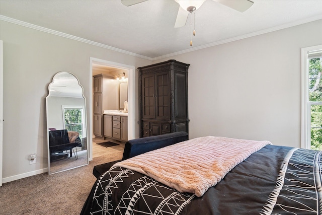 carpeted bedroom featuring multiple windows, ensuite bath, ceiling fan, and crown molding