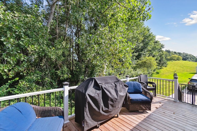 wooden terrace with a grill and a yard