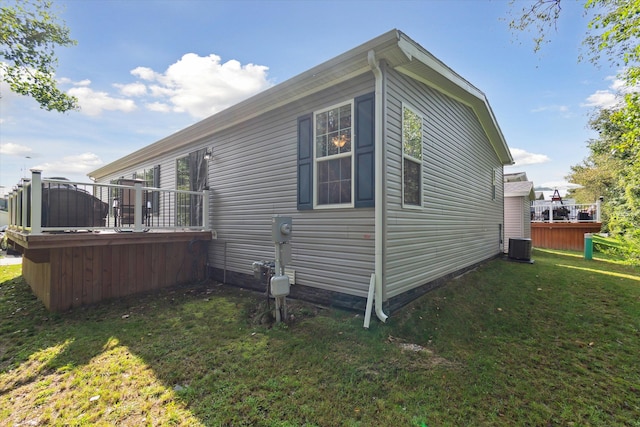 view of property exterior featuring a lawn, central air condition unit, and a deck