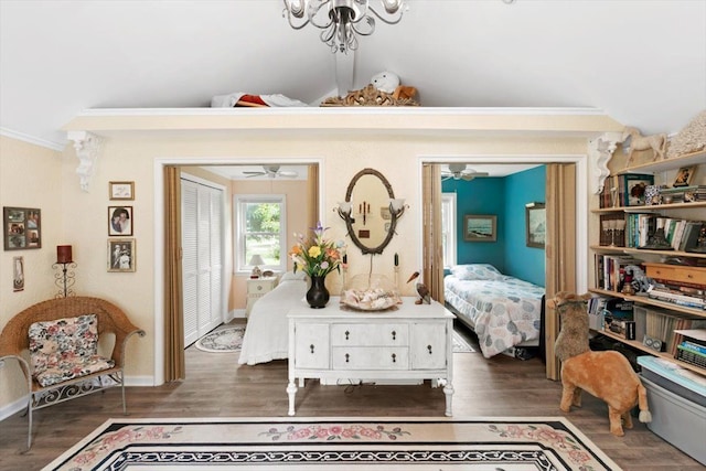 bedroom featuring vaulted ceiling, crown molding, dark wood-type flooring, and a closet