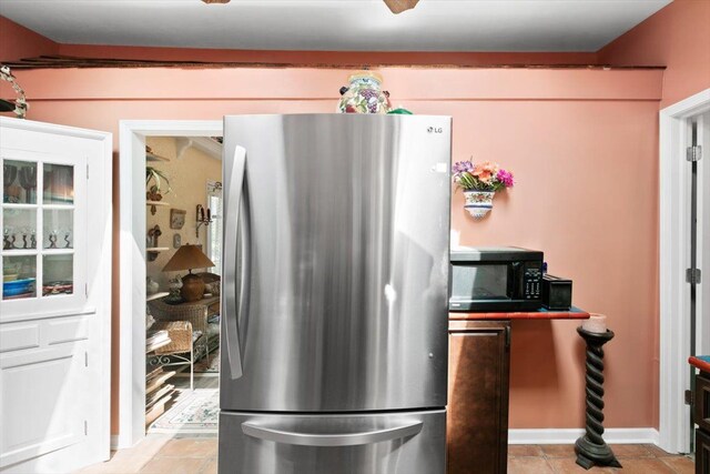 7400 Aspen Rd, Lexington, MI 48450 - kitchen featuring freestanding refrigerator, black microwave, and light tile patterned floors
