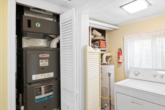 clothes washing area with washer / clothes dryer, water heater, and heating unit