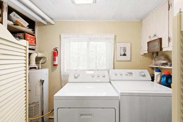 laundry room with washing machine and dryer, gas water heater, and wood walls