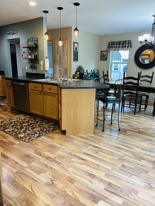 kitchen with stainless steel dishwasher, a breakfast bar, light hardwood / wood-style floors, and pendant lighting