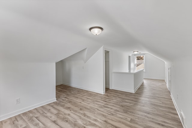 additional living space featuring light hardwood / wood-style floors and lofted ceiling