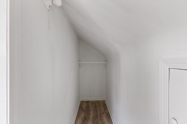 walk in closet featuring hardwood / wood-style flooring and vaulted ceiling