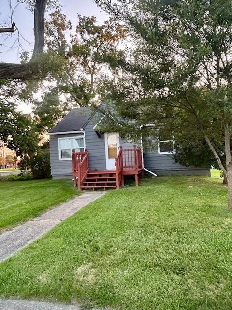 back of property with a yard and a wooden deck