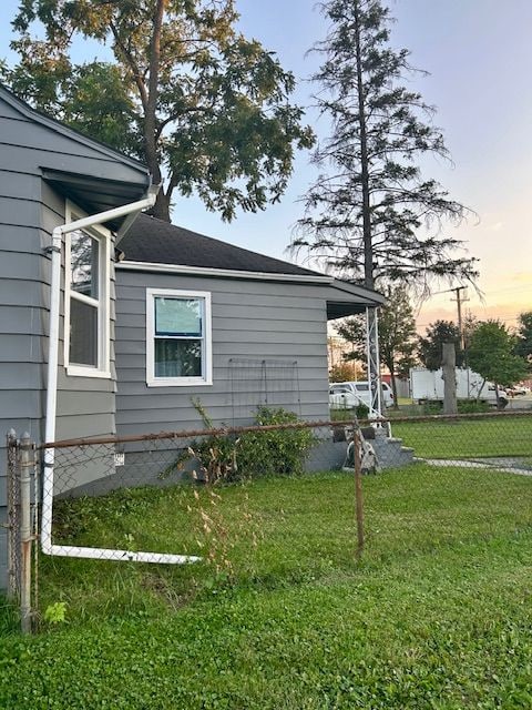 property exterior at dusk featuring a yard