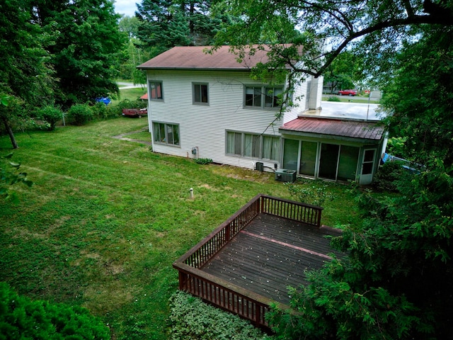 rear view of house featuring a yard and a wooden deck