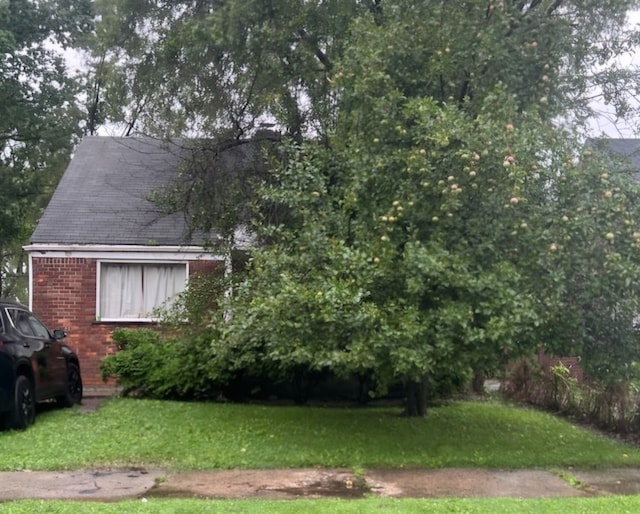 view of side of home with a yard