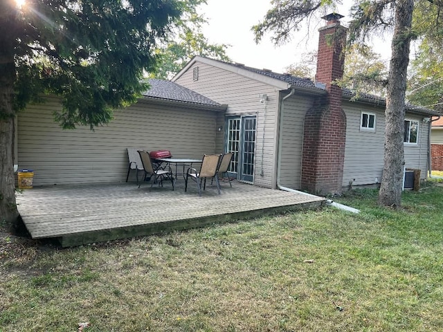 back of house with central AC, a deck, and a lawn