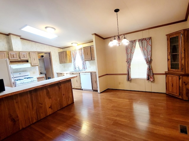 kitchen featuring hanging light fixtures, hardwood / wood-style floors, a chandelier, and white appliances