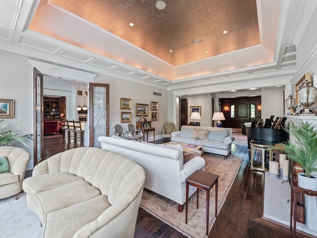 living room with dark hardwood / wood-style floors, a raised ceiling, and ornamental molding