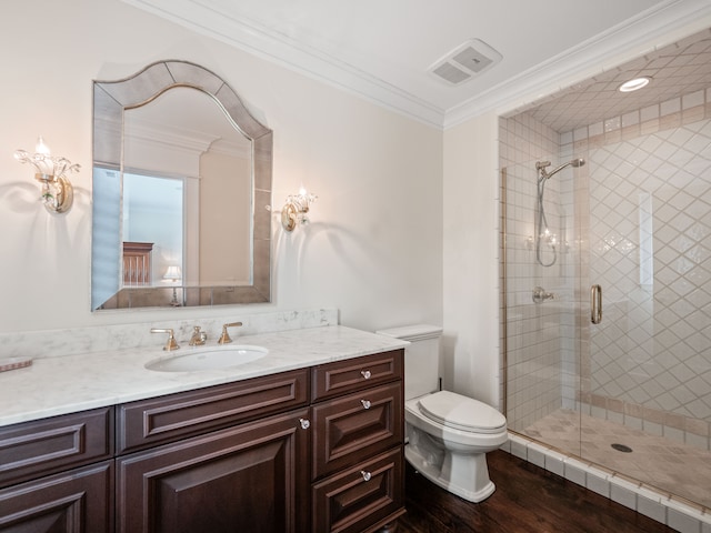 bathroom with ornamental molding, vanity, wood-type flooring, toilet, and a shower with shower door