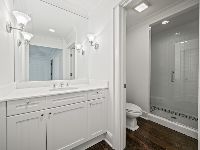 bathroom with vanity, a shower with door, hardwood / wood-style flooring, toilet, and ornamental molding