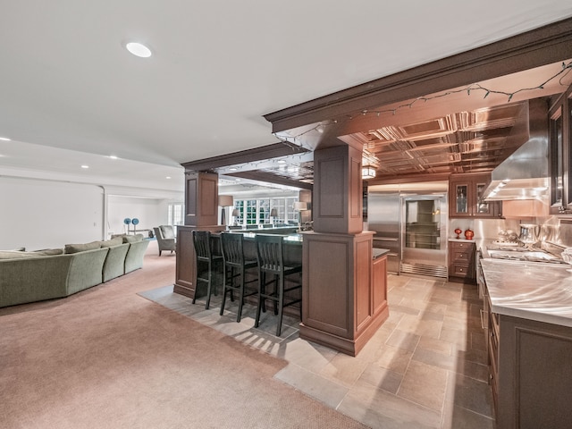 bar featuring light colored carpet and wall chimney range hood