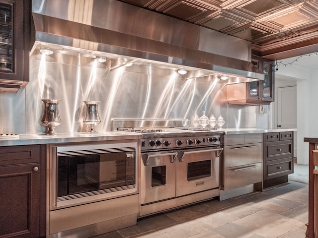 kitchen with exhaust hood, stainless steel counters, and stainless steel appliances