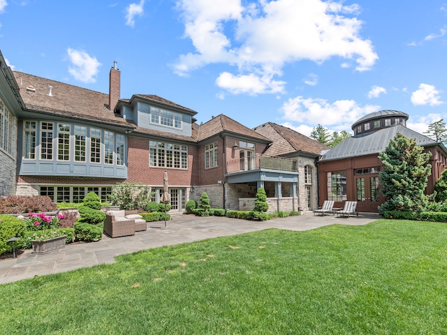 back of property featuring a lawn, a patio area, and french doors