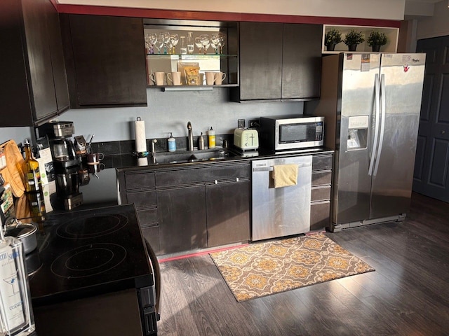 kitchen featuring dark brown cabinets, sink, dark wood-type flooring, and appliances with stainless steel finishes