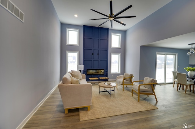 living room with a wealth of natural light, a large fireplace, and hardwood / wood-style floors