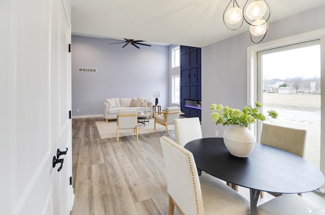 dining area with ceiling fan and light wood-type flooring