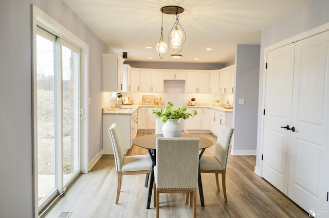 dining room with sink and light hardwood / wood-style flooring