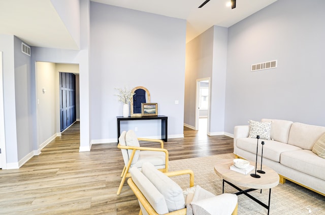 living room featuring ceiling fan, hardwood / wood-style floors, and high vaulted ceiling