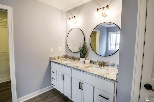 4911 Skylark Dr, Monroe, MI 48161 - full bathroom featuring double vanity, a spacious closet, a sink, and wood finished floors