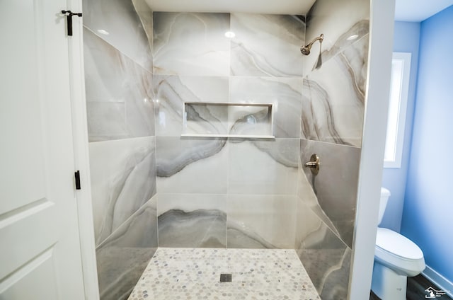 bathroom featuring toilet and tiled shower