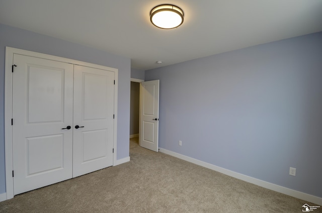 unfurnished bedroom featuring a closet and light carpet