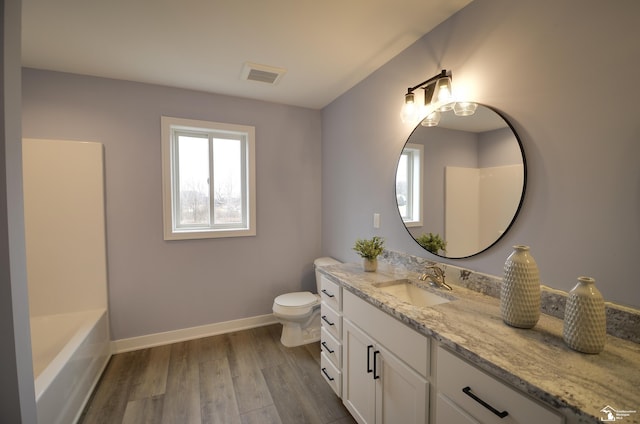 full bathroom with vanity, hardwood / wood-style floors, toilet, and washtub / shower combination