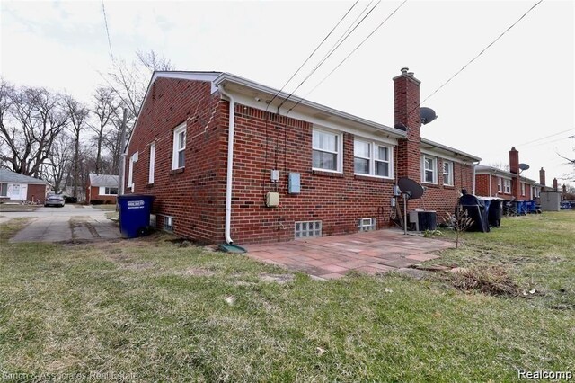 2439 Stieber St, Westland, MI 48186 - back of property featuring a lawn, brick siding, a chimney, and a patio