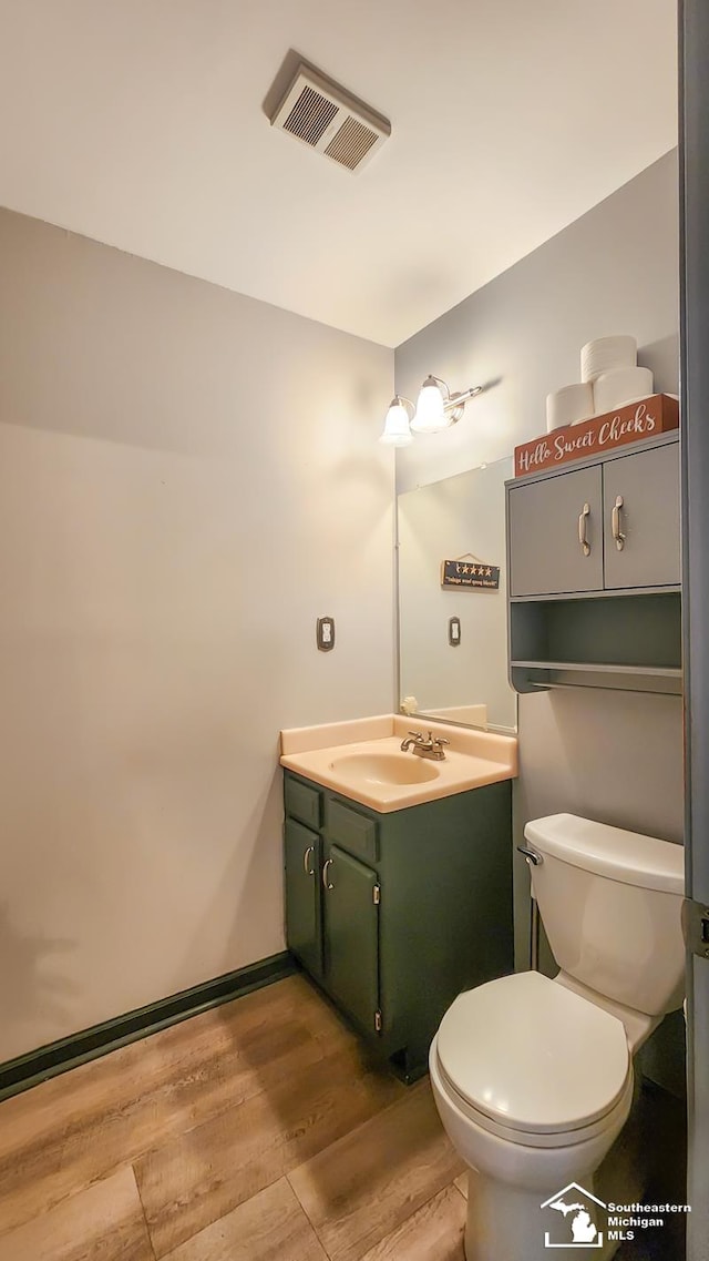 bathroom featuring hardwood / wood-style floors, vanity, and toilet