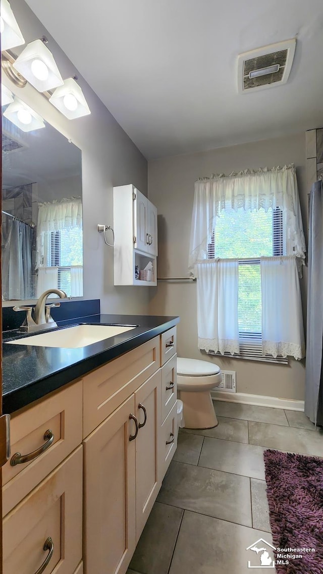 bathroom with tile patterned flooring, vanity, and toilet