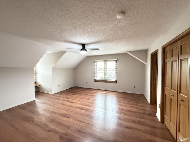 bonus room with a textured ceiling, ceiling fan, vaulted ceiling, and hardwood / wood-style flooring