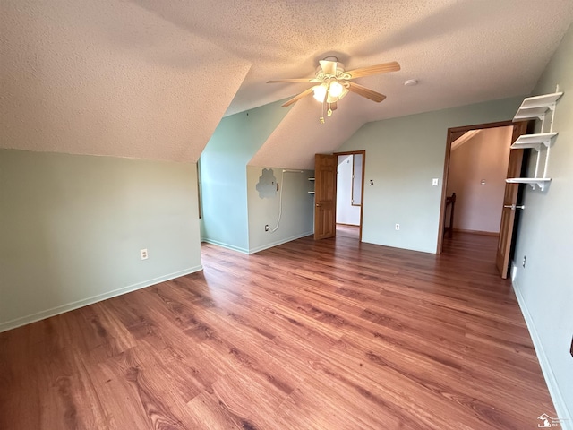 bonus room featuring a textured ceiling, ceiling fan, hardwood / wood-style floors, and vaulted ceiling