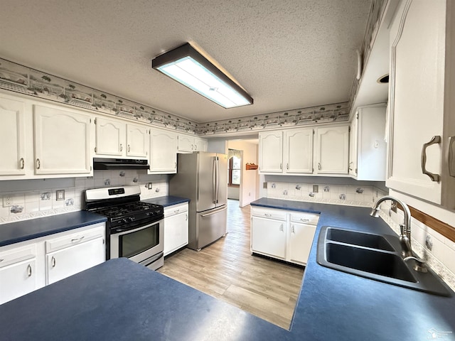 kitchen with sink, stainless steel appliances, a textured ceiling, white cabinets, and light wood-type flooring